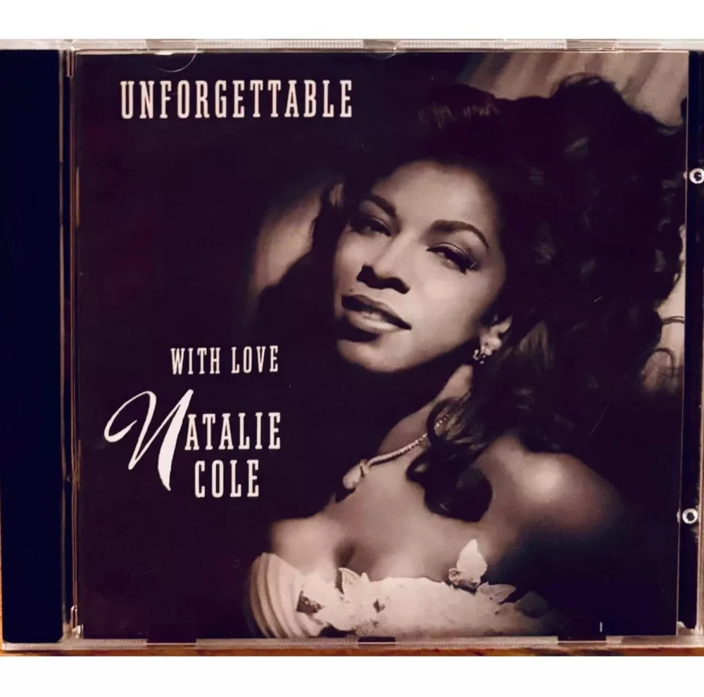CD case with "Unforgettable... With Love" album cover. Natalie Cole wearing an off-shoulder white dress with floral embellishments. Black and white photo.
